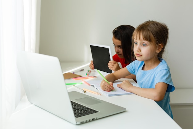 Studentesse piuttosto eleganti che studiano durante la sua lezione online a casa, distanza sociale durante la quarantena, autoisolamento, concetto di educazione online