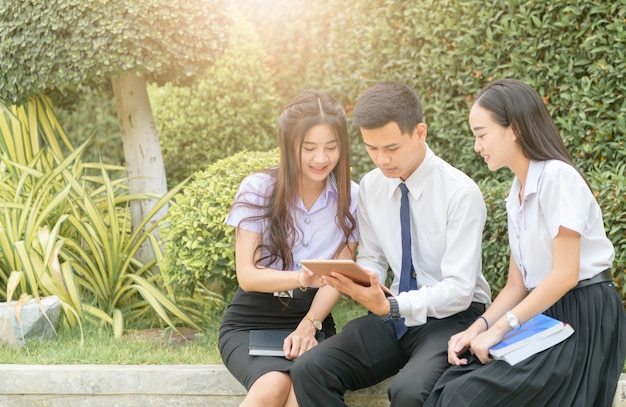 Studenti asiatici che utilizzano la tavoletta per fare i compiti