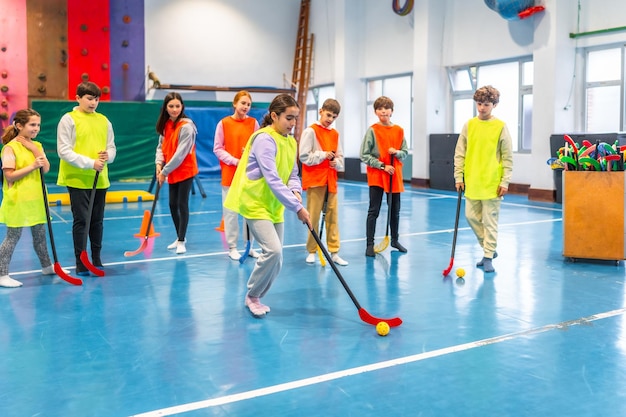 Studenti che giocano a floorball in classe di ginnastica a scuola