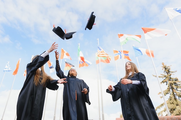 Studenti che lanciano cappelli da laurea in aria per festeggiare
