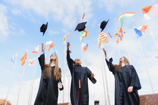 Studenti che lanciano cappelli da laurea in aria per festeggiare