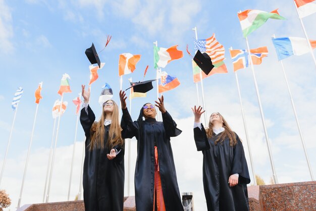 Studenti che lanciano cappelli da laurea in aria per festeggiare