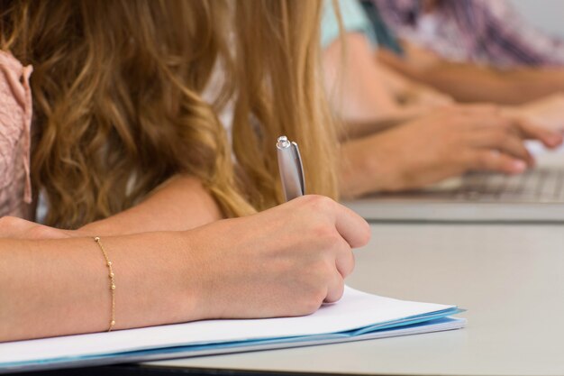 Studenti che scrivono appunti in aula