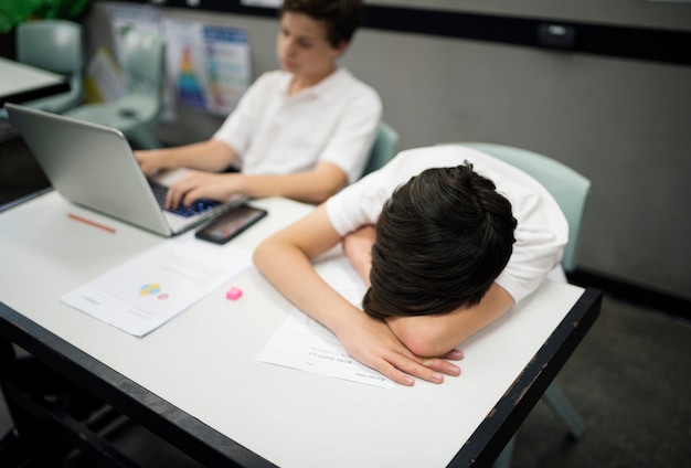 Studenti che studiano e sonnecchiano su una scrivania