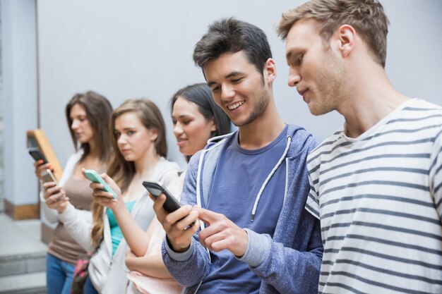 Studenti che usano i loro smartphone di fila