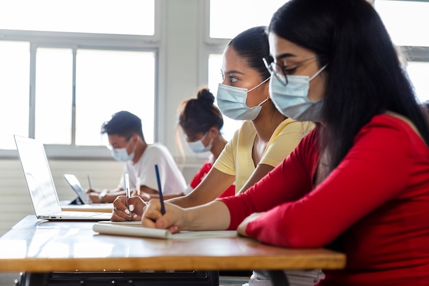 Studenti delle scuole superiori adolescenti multirazziali in classe che indossano la maschera facciale Copia spazio Istruzione Healthcare