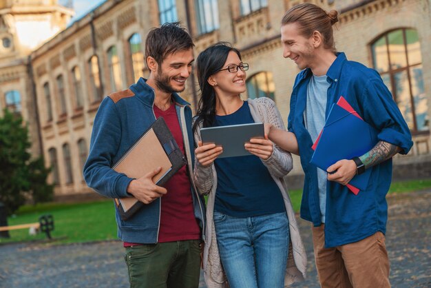 Studenti felici che utilizzano la tecnologia moderna all'aperto