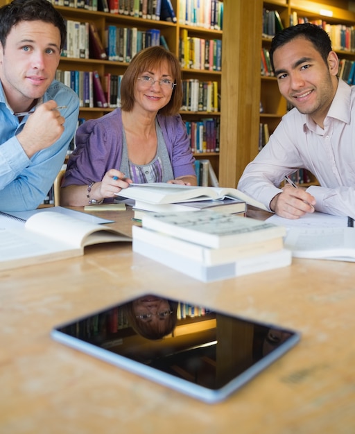 Studenti maturi che studiano insieme nella biblioteca