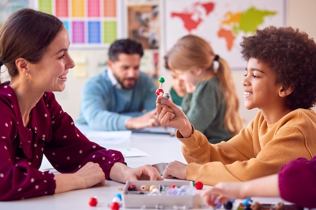 Studenti multiculturali con insegnanti in classe che studiano il modello molecolare in classe di scienze