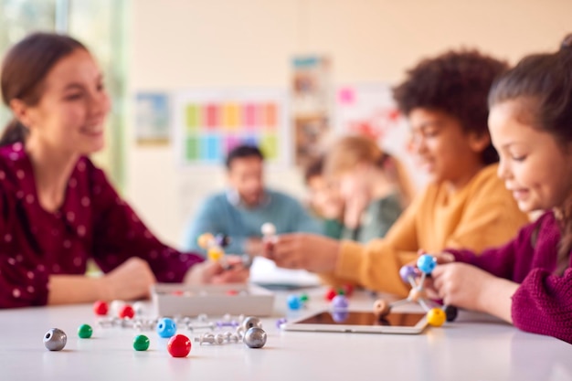 Studenti multiculturali con insegnanti in classe che studiano il modello molecolare in classe di scienze