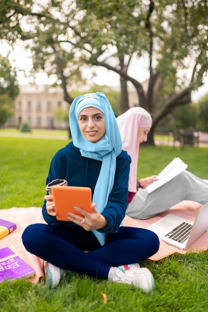 Studenti musulmani impegnati. Vista dall'alto di studenti musulmani che usano gadget mentre studiano una lingua straniera