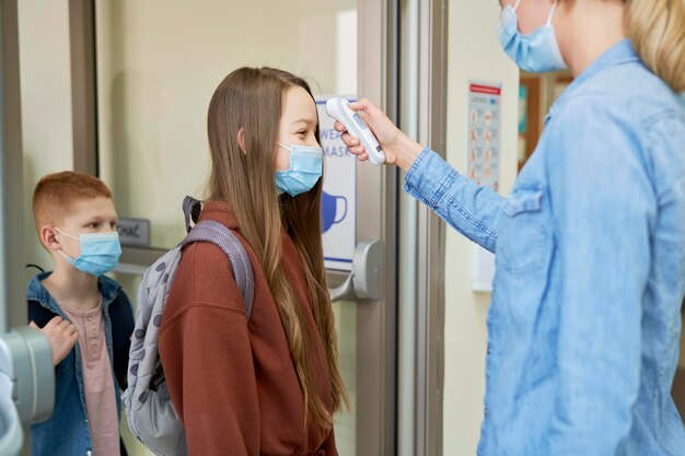 Studenti nell'edificio scolastico controllati per il controllo della temperatura