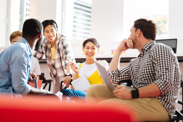 Studenti rilassati. Studenti emotivi positivi che sorridono e sembrano contenti mentre erano seduti alla lezione e ridono