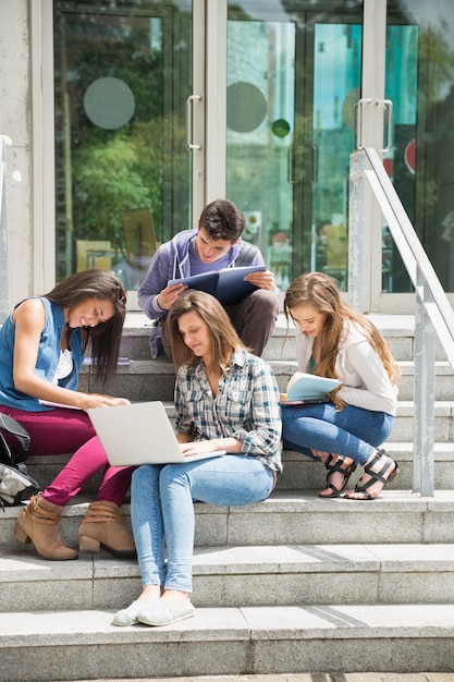 Studenti seduti sui gradini che studiano