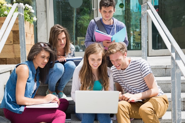 Studenti seduti sui gradini che studiano