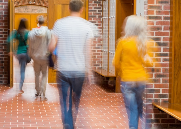 Studenti sfocati che camminano attraverso il corridoio