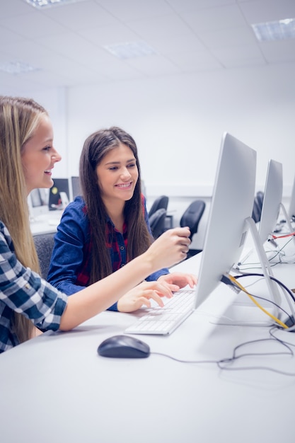 Studenti sorridenti che lavorano al computer all&#39;università