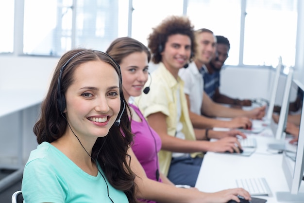 Studenti sorridenti che utilizzano gli auricolari nella classe del computer