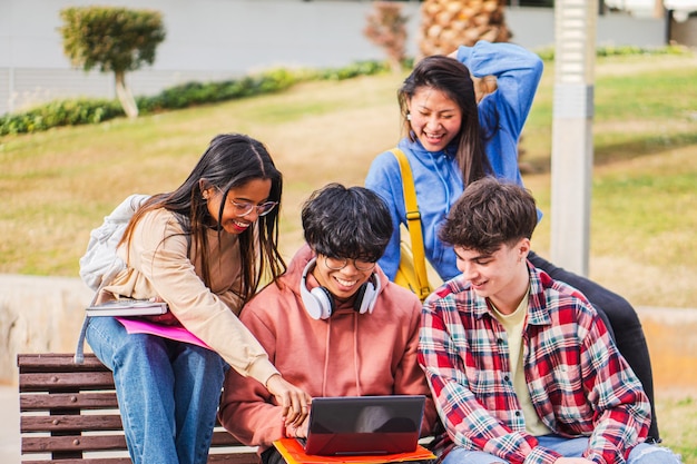 Studenti universitari che utilizzano laptop nel campus che studiano insieme