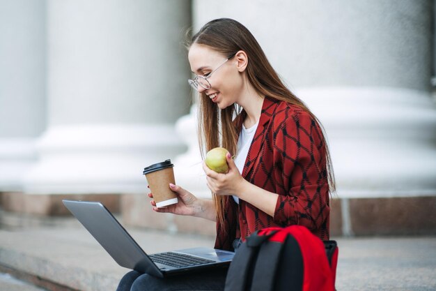 Studia spuntini per aiutare a rivedere il cibo per il cervello durante il periodo dell'esame felice studentessa universitaria con mela e