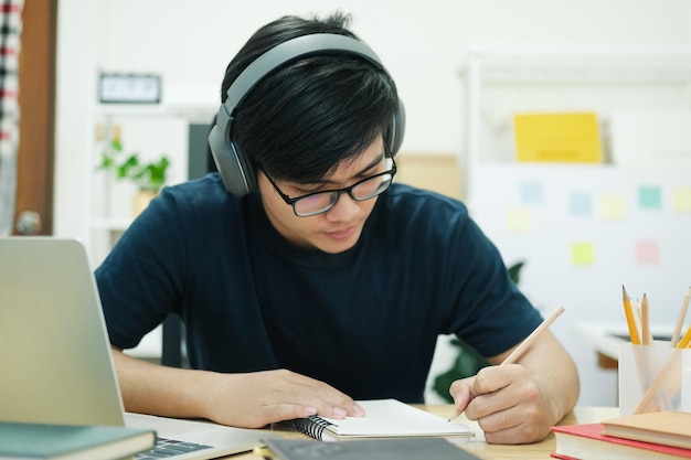 Studio del giovane davanti al computer portatile a casa