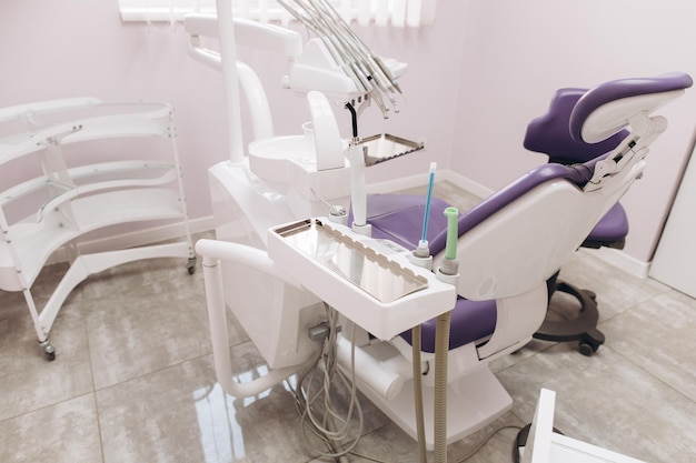 Studio dentistico moderno Poltrona odontoiatrica e altri accessori utilizzati dai dentisti in luce rame viola