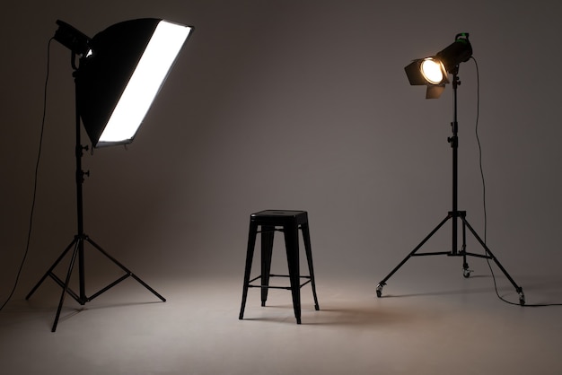 Studio fotografico con apparecchi di illuminazione. schema luci e sedia. Il concetto di selezione e casting. Annuncio di reclutamento di lavoro.