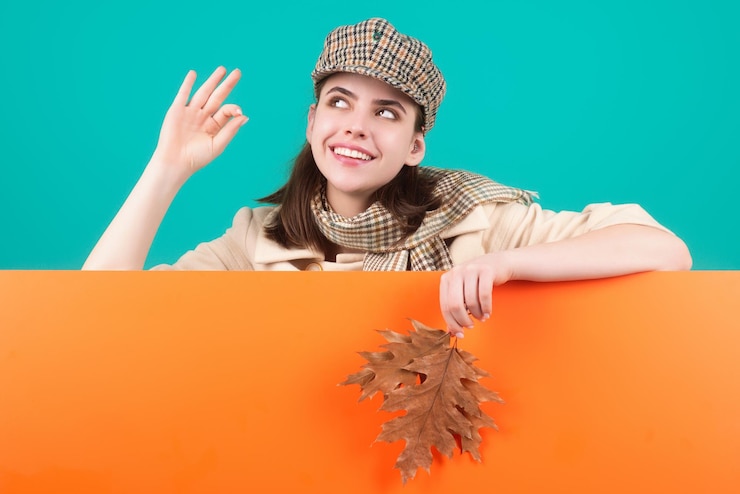 Photo studio portrait of young woman with autumn fall leaves