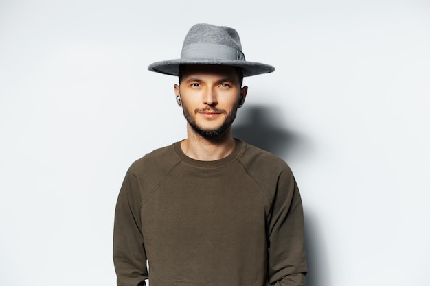 Studio ritratto di giovane uomo attraente che indossa il cappello grigio