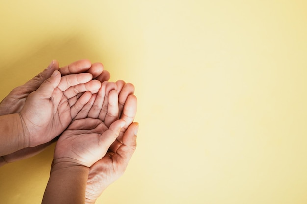 Studio shot Closeup vista superiore delle mani della famiglia impilate su uno sfondo isolato Genitori e bambino tengono insieme uno spazio vuoto che rappresenta il Giorno della Famiglia e dei Genitori