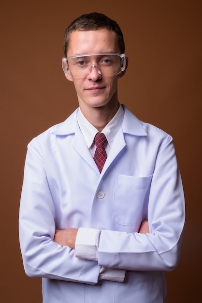 Studio shot del giovane medico su colore marrone