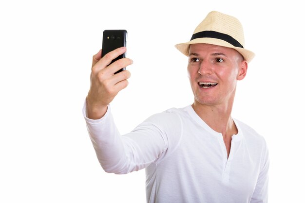 Studio shot del giovane uomo felice sorridente mentre si scatta una foto selfie