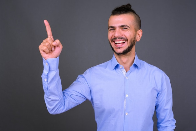 Studio shot di bel imprenditore turco su sfondo grigio