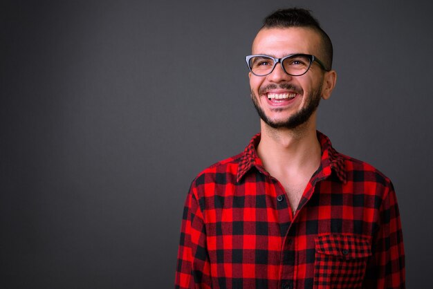 Studio shot di bel turco uomo che indossa occhiali da vista contro uno sfondo grigio