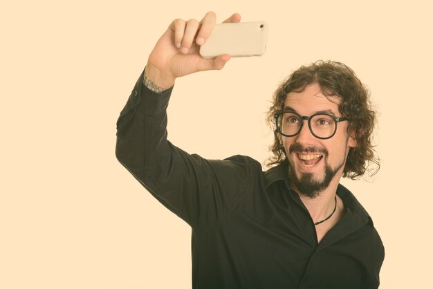 Studio shot di bell'uomo d'affari barbuto con capelli ricci isolato su bianco