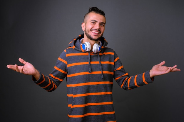 Studio shot di bell'uomo turco che indossa le cuffie su uno sfondo grigio