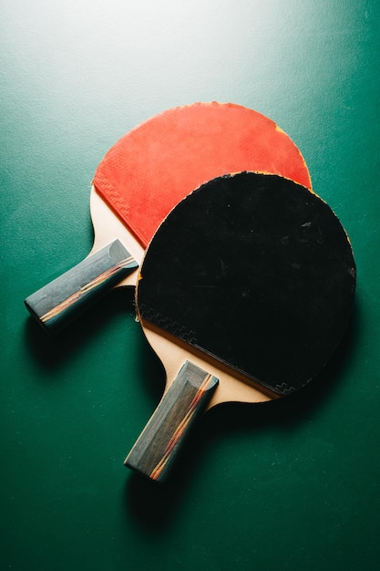 Studio shot di due racchette da ping pong sono sul tavolo da gioco verde