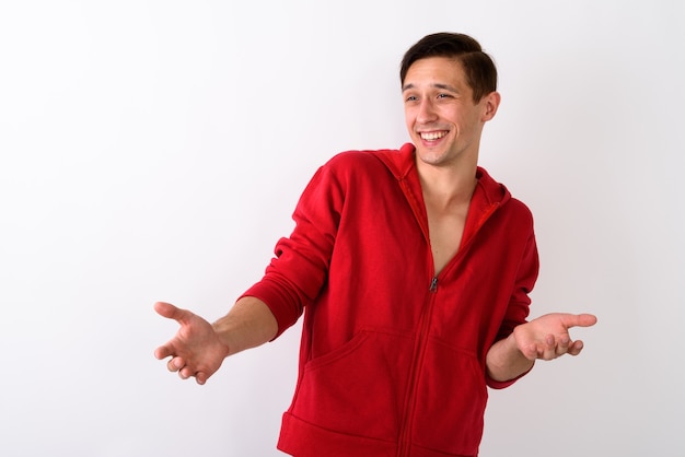 Studio shot di felice giovane uomo bello sorridente mentre guarda co