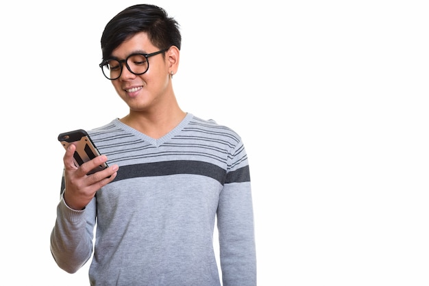 Studio shot di felice uomo asiatico sorridente mentre si utilizza il telefono cellulare