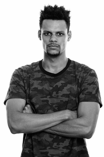 Studio shot di giovane bello barbuto uomo africano con capelli afro isolata contro uno sfondo bianco in bianco e nero