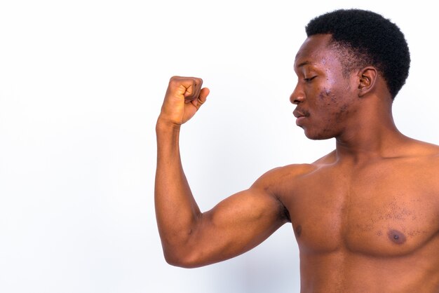 Studio shot di giovane uomo africano bello a torso nudo su sfondo bianco