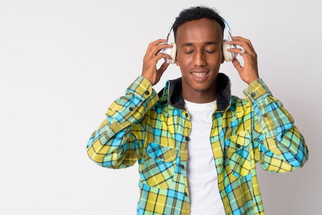 Studio shot di giovane uomo bello hipster africano con capelli afro contro bianco