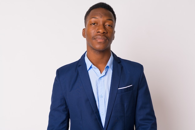 Studio shot di giovane uomo d'affari africano bello con i capelli afro su sfondo bianco