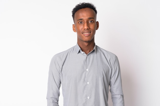 Studio shot di giovane uomo d'affari bello con i capelli afro contro il bianco