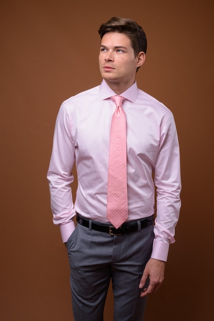 Studio shot di giovane uomo d'affari bello con la camicia rosa