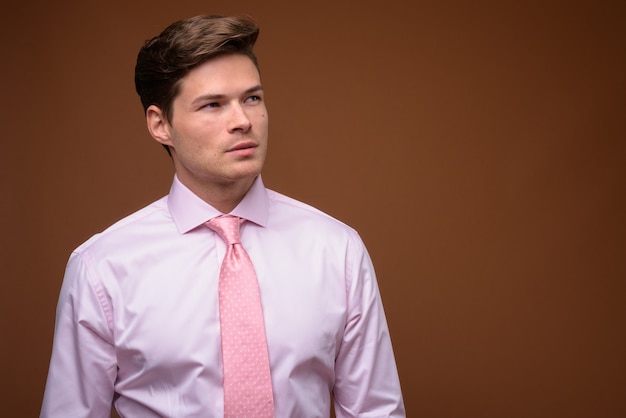 Studio shot di giovane uomo d'affari bello con la camicia rosa