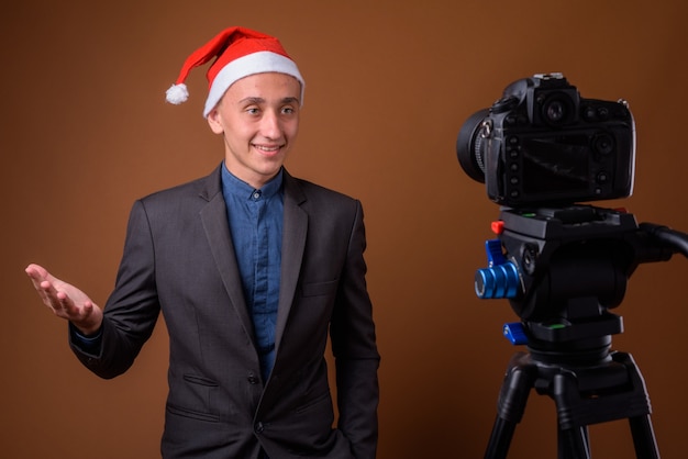 Studio shot di giovane uomo d'affari bello contro marrone