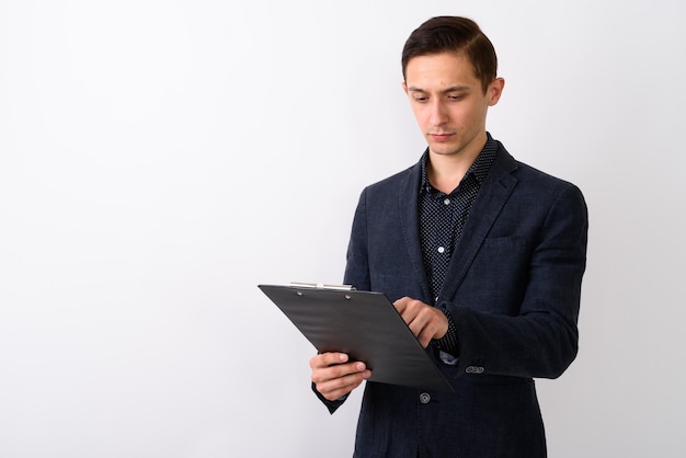 Studio shot di giovane uomo d'affari handsome che legge negli appunti a