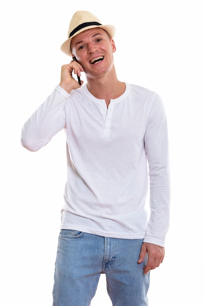 Studio shot di giovane uomo felice sorridente e in piedi mentre si parla