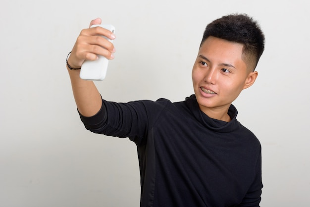 Studio shot di giovani asiatici donna lesbica con i capelli corti su sfondo bianco